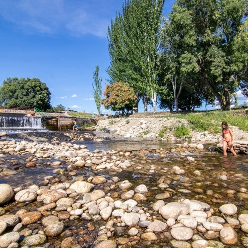 Personas disfrutando de un baño en una piscina natural.